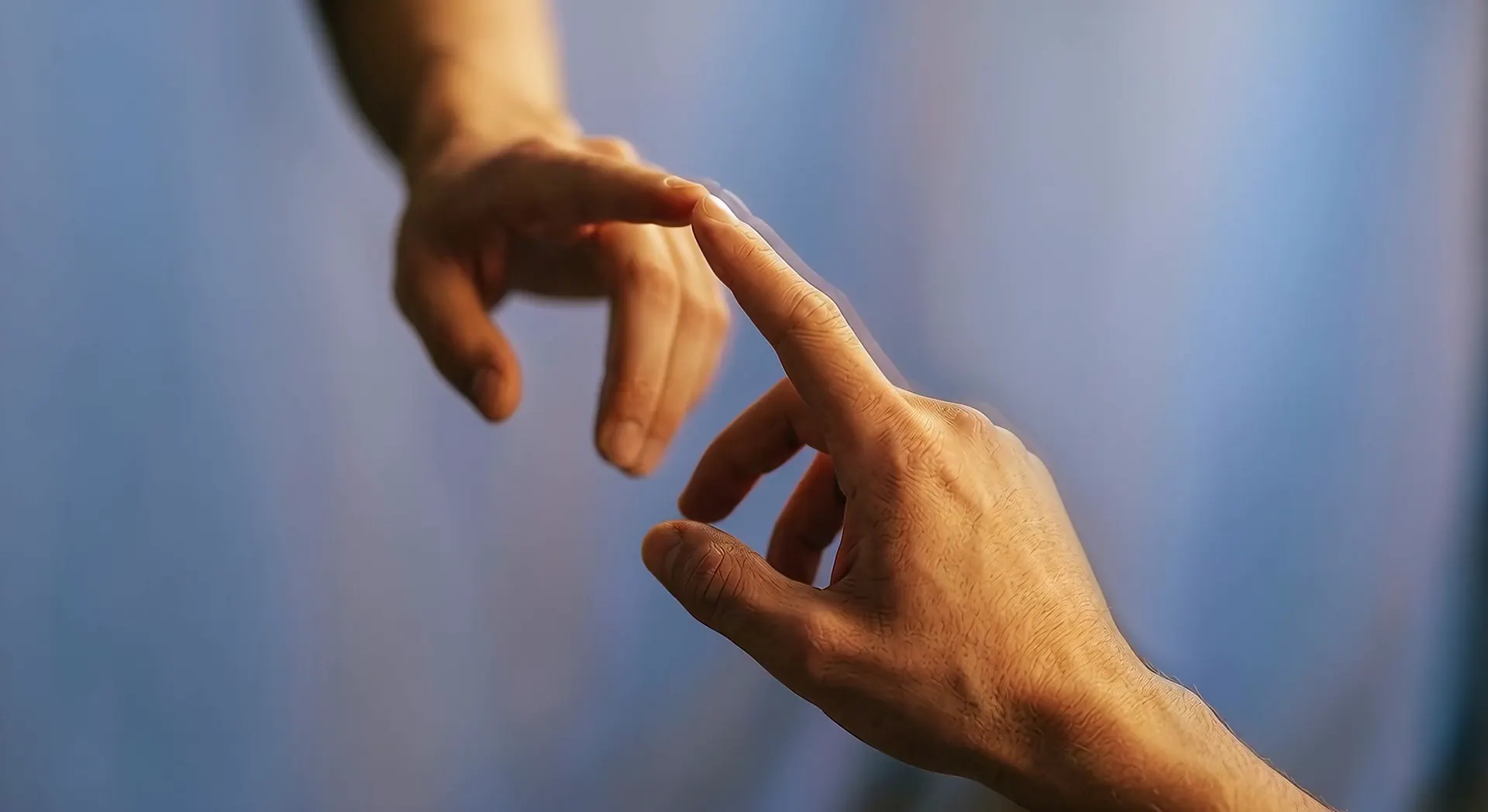 Two hands, fingertips touching, in warm light against a blue ground